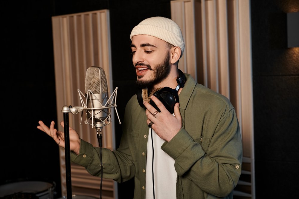 A man recording recitation audio into a studio microphone