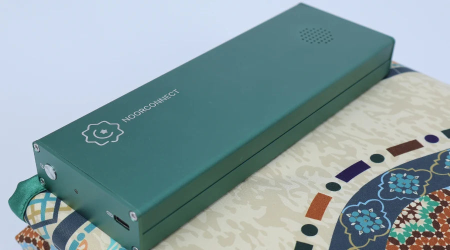 The NoorConnect control module resting on the mat's patterned border